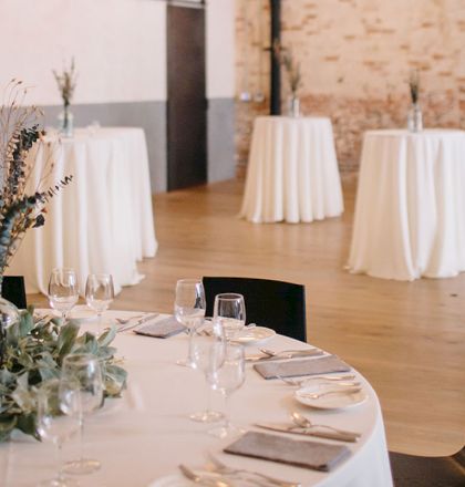 A cozy dining setup with a wooden table, chairs, candles, and a rustic background, inviting and warm ambiance.