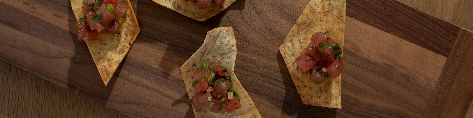 Bruschetta-like flatbread triangles with diced tomatoes, onions, and herbs on a wooden board.
